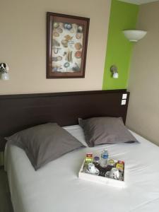 a tray of food sitting on top of a bed at Initial by balladins Dieppe in Saint-Aubin-sur-Scie