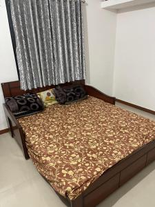 a bed in a room with a window with a bedspread at hotel home stay shiv farm in Gandhinagar