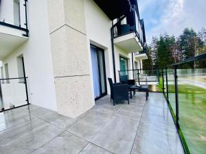a balcony of a building with a table and chairs at Apartamenty Przełom Białki - plac zabaw, wiata grillowa in Białka Tatrzanska