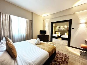 Habitación de hotel con cama grande y espejo en REGALPARK Hotel Kuala Lumpur, en Kuala Lumpur