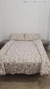 - un lit avec une couette grise et blanche dans l'établissement Monolocale piano terra 35mq, à Francavilla al Mare