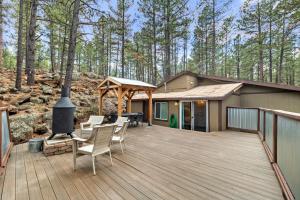 a wooden deck with chairs and a grill on a house at The Cozy Cottage in Flagstaff