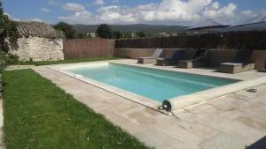uma piscina no quintal de uma casa em Villa de 6 chambres avec piscine privee jardin clos et wifi a Saint Saturnin les Apt em Saint-Saturnin-dʼApt