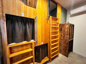 a room with a tv and a bunk bed at ゲストハウス JOOOY Hotel 奄美 in Amami