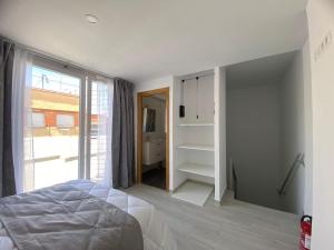 1 dormitorio con cama y ventana grande en La Pilarica, en Madrid
