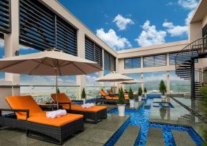 an outdoor patio with orange chairs and umbrellas at Apartment with Ocean view in Danang