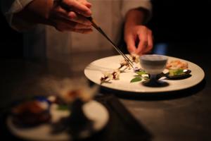 京丹後的住宿－雷索匹亞久美浜酒店，用刀子切一盘食物的人