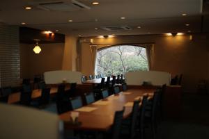 una sala de conferencias con una mesa larga y sillas en Resorpia Kumihama, en Kyotango