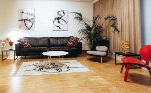un soggiorno con divano nero e tavolo di R213 Residences Botanique a Bruxelles