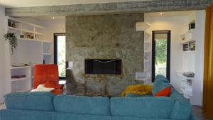 a living room with a blue couch and a fireplace at Villa Quadrille in Lorgues