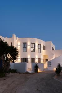 un edificio blanco con luces encendidas por la noche en Bedspot Apartments Paros, en Naousa