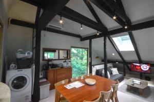 ein Wohnzimmer mit einem Esstisch und einer Waschmaschine in der Unterkunft Hakuba Cottage Karamatsu in Hakuba