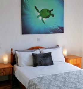 een slaapkamer met een bed met een schildpadschilderij aan de muur bij Sky Villa in Paphos City