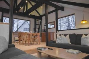 ein Wohnzimmer mit einem Sofa und einem Tisch in der Unterkunft Hakuba Cottage Karamatsu in Hakuba
