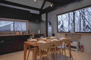 a dining room with a table and chairs in a kitchen at Hakuba Cottage Karamatsu in Hakuba +41 photos