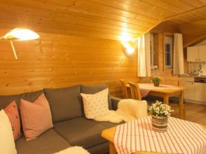 uma sala de estar com um sofá e uma mesa em Tranquil holiday home with large garden em Balderschwang