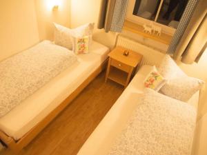 um pequeno quarto com 2 camas e uma janela em Tranquil holiday home with large garden em Balderschwang