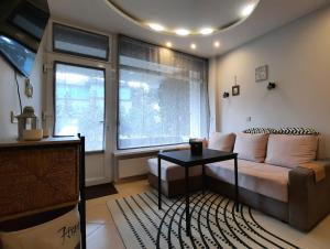 een woonkamer met een bank en een tafel bij Apartamentai su terasa Rugelyje in Palanga