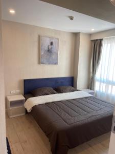 a bedroom with a large bed with a blue headboard at Seven Seas Condo Pattaya in Jomtien Beach