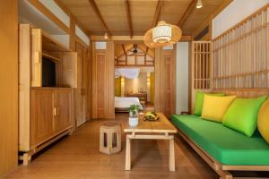 a living room with a green couch and a table at Six Senses Qing Cheng Mountain in Chengdu