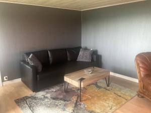a living room with a black couch and a coffee table at Klinta sea view in Köpingsvik