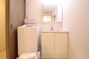 a small kitchen with a sink and a refrigerator at King's House in Osaka +29 photos