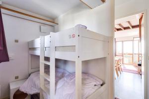 Ce lit superposé blanc se trouve dans un dortoir doté d'une fenêtre. dans l'établissement Résidence Quartier Falaise - maeva Home - Appartement 2 pièces 7 personnes 844, à Avoriaz