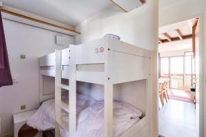 Ce lit superposé blanc se trouve dans un dortoir doté d'une fenêtre. dans l'établissement Résidence Quartier Falaise - maeva Home - Appartement 2 pièces 7 personnes - Sélection MAE-2844, à Avoriaz