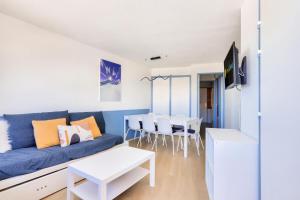 a living room with a blue couch and a table at Résidence Quartier Falaise - maeva Home - Appartement 2 pièces 7 personnes 454 in Avoriaz