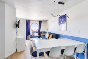 a dining room with a white table and blue chairs at Résidence Quartier Falaise - maeva Home - Appartement 2 pièces 7 personnes 454 in Avoriaz
