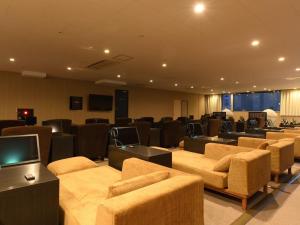 a conference room with couches and chairs and a tv at The Centurion Sauna Rest & Stay Sapporo Male Only in Sapporo