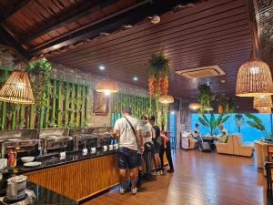 a group of people standing at a bar in a restaurant at Kawasaki Noi Bai Hotel in Noi Bai