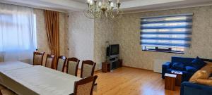 卡希的住宿－Kirayə ev, Qax, Qaşqaçay guesthouse，一间带桌子和蓝色沙发的用餐室
