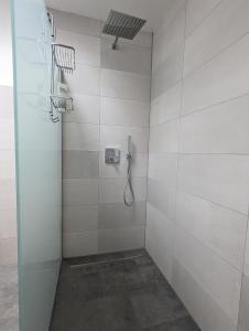 a bathroom with a shower with white tiles at Ferienwohnung Urban -Ekhof- in Gotha