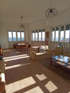 sala de estar con sofás, mesa y ventanas en LOCANDA DEI FOLLI, en Roccamonfina