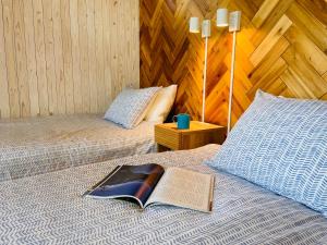 a book laying on top of a bed with a pillow at PACIFICO SURF HOUSE - by the Sea in Shishikui