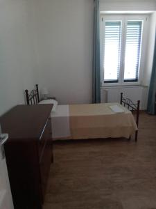 1 dormitorio con cama, escritorio y ventana en LOCANDA DEI FOLLI, en Roccamonfina