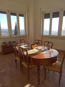 comedor con mesa, sillas y ventanas en LOCANDA DEI FOLLI, en Roccamonfina