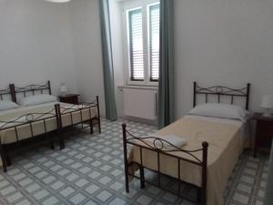 a room with two beds and a window in it at LOCANDA DEI FOLLI in Roccamonfina