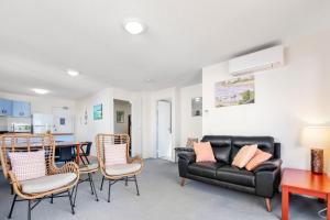 a living room with a black leather couch and chairs at Jade Waters U4 5 Latona Ave in Caloundra