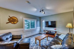 a living room with leather couches and a flat screen tv at Nautical Nook 2 Bedroom Getaway with Ocean Views in Kodiak