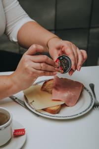 a person is holding a clock next to a plate of food at Hotel Zaragoza Plaza in Donostia-San Sebastián