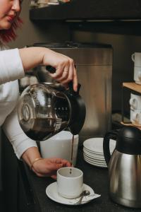 a woman pouring coffee into a cup on a counter at Hotel Zaragoza Plaza in Donostia-San Sebastián