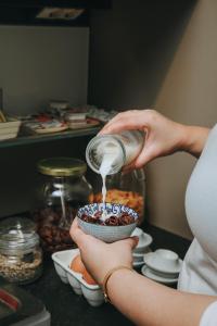 a woman is pouring food into a cupcake at Hotel Zaragoza Plaza in Donostia-San Sebastián