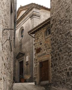 un antiguo edificio de piedra con una puerta en una calle en Abbergà, en Santa Fiora