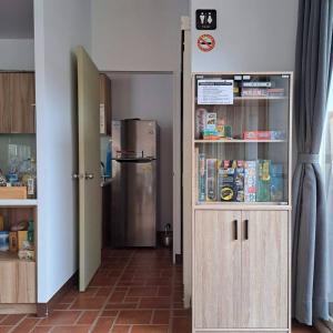 a kitchen with a refrigerator and a door to a room at TipsyHotel in Jincheng