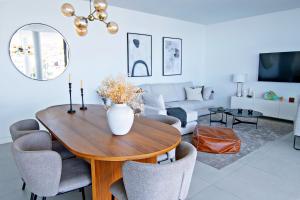 uma sala de estar com uma mesa de madeira e cadeiras em Mara's Apartments Higueron West - Like A House - 246 Square Meters of Private Terrace & Garden - Morning and Evening Sun em Fuengirola