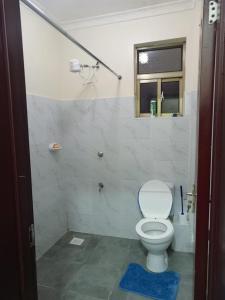 a bathroom with a white toilet and a window at Atalia Athi River in Nairobi