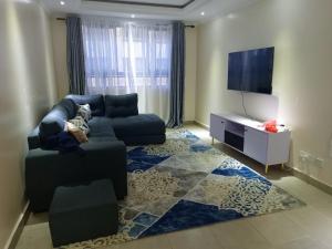 a living room with a couch and a flat screen tv at Atalia Athi River in Nairobi