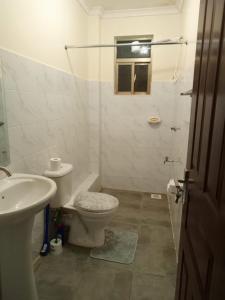 a white bathroom with a toilet and a sink at Atalia Athi River in Nairobi